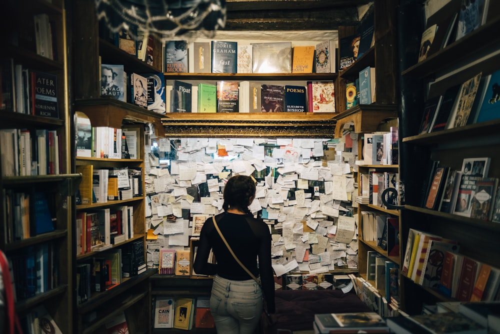 図書館の中に立っている白いシャツを着た女性