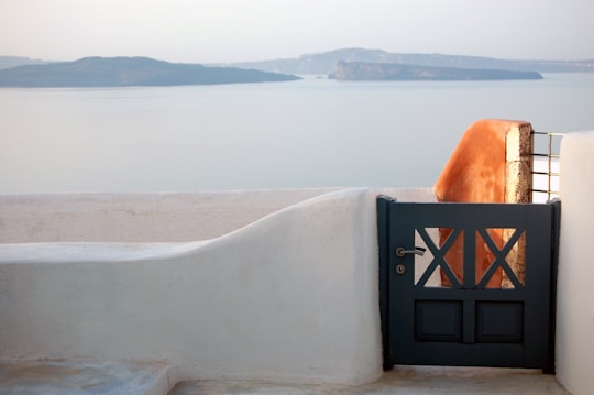 black steel gate near body of water during daytime in Thera Greece