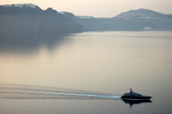 A serene sunset over a pristine beach with a luxury yacht anchored nearby, evoking the essence of exclusive travel.