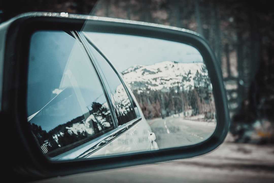 snow-capped mountain view from gray vehicle's right side mirror