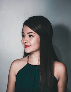 Professional portrait of a young woman in a sleek outfit against a minimalist backdrop.