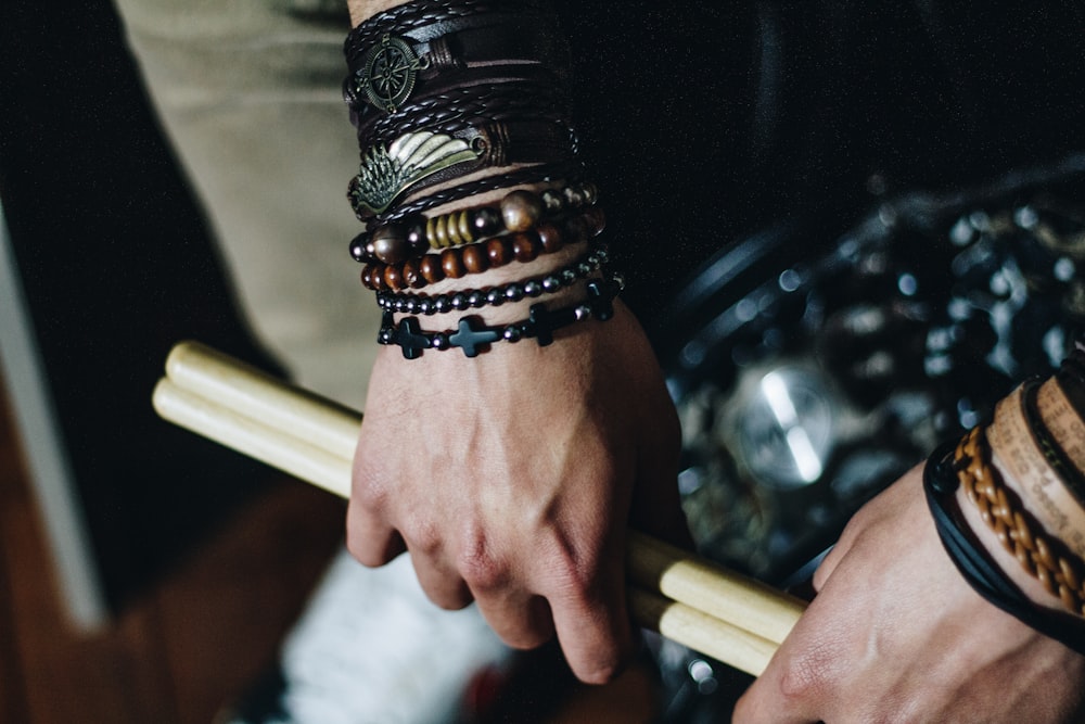 person holding pair of brown drum sticks