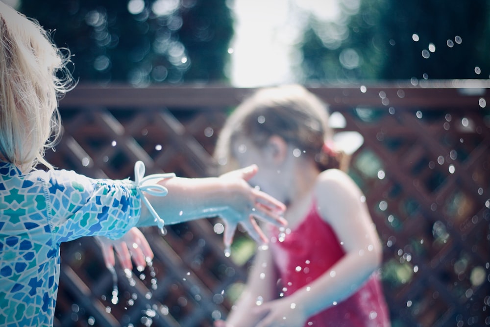 zwei Kinder spielen mit Wasser