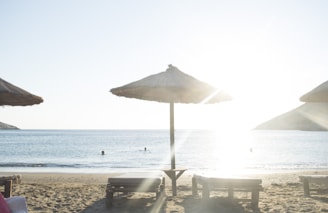 white patio umbrella near body of water