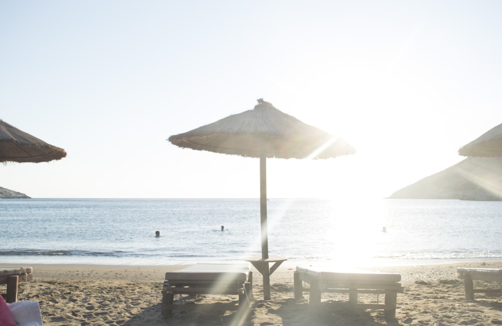 white patio umbrella near body of water