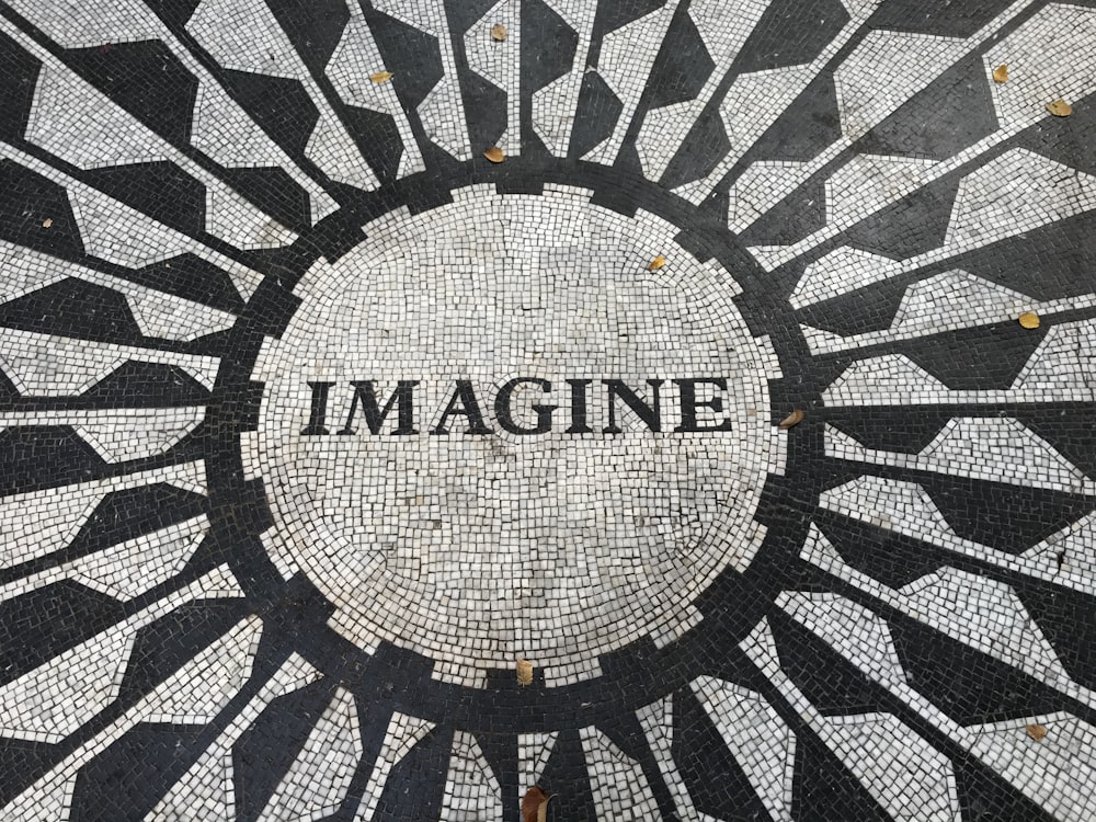 A mosaic of the word Imagine in black and white, with geometric patterns radiating outwards from the word in the middle