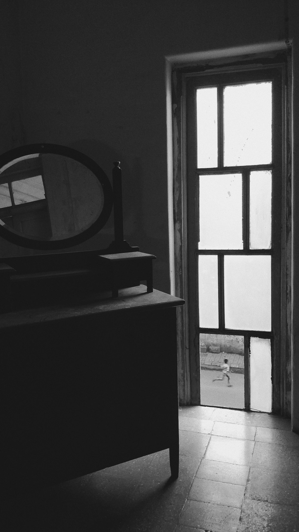 grayscale photo of dresser with mirror