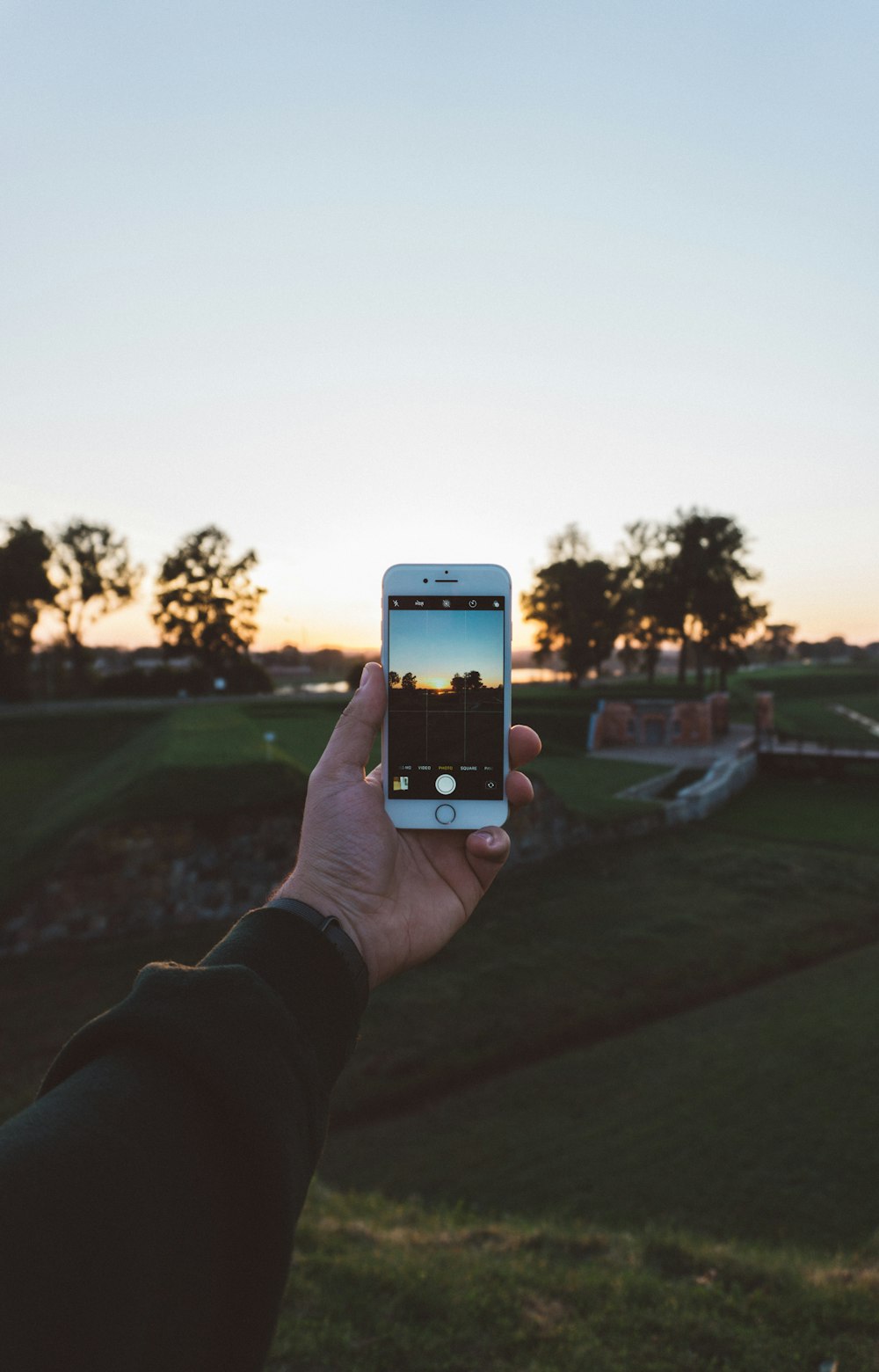 person holding iPhone white taking picture during daytime