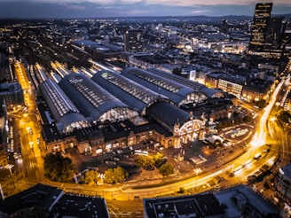 A vibrant city train station bustling with travelers and glowing lights.