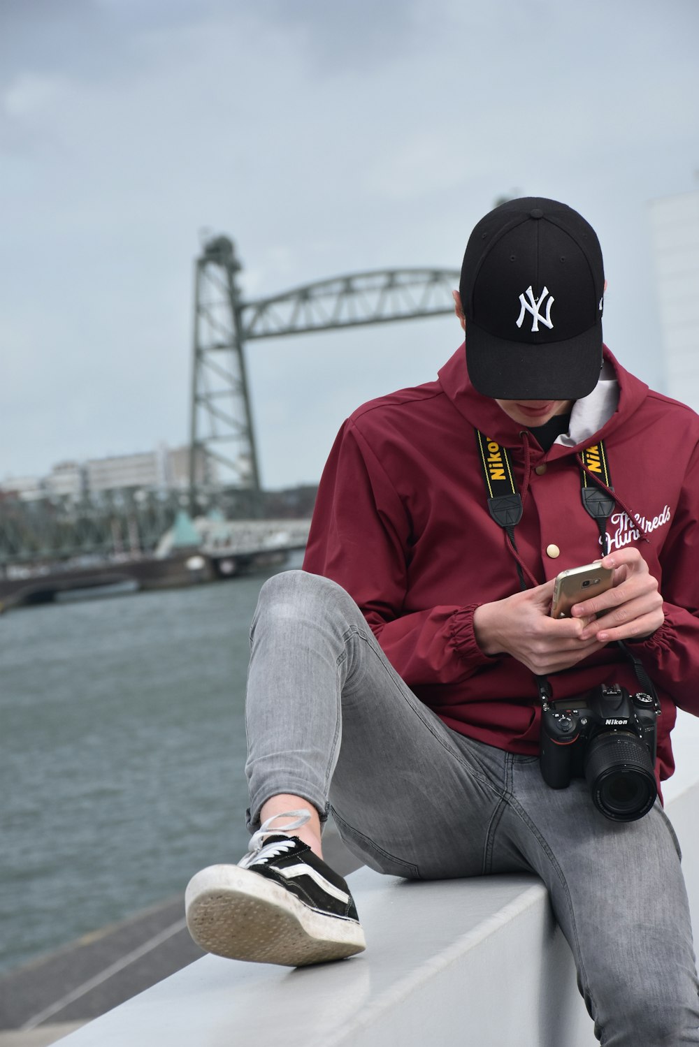 photographie sélective d’un homme assis à l’aide d’un iPhone