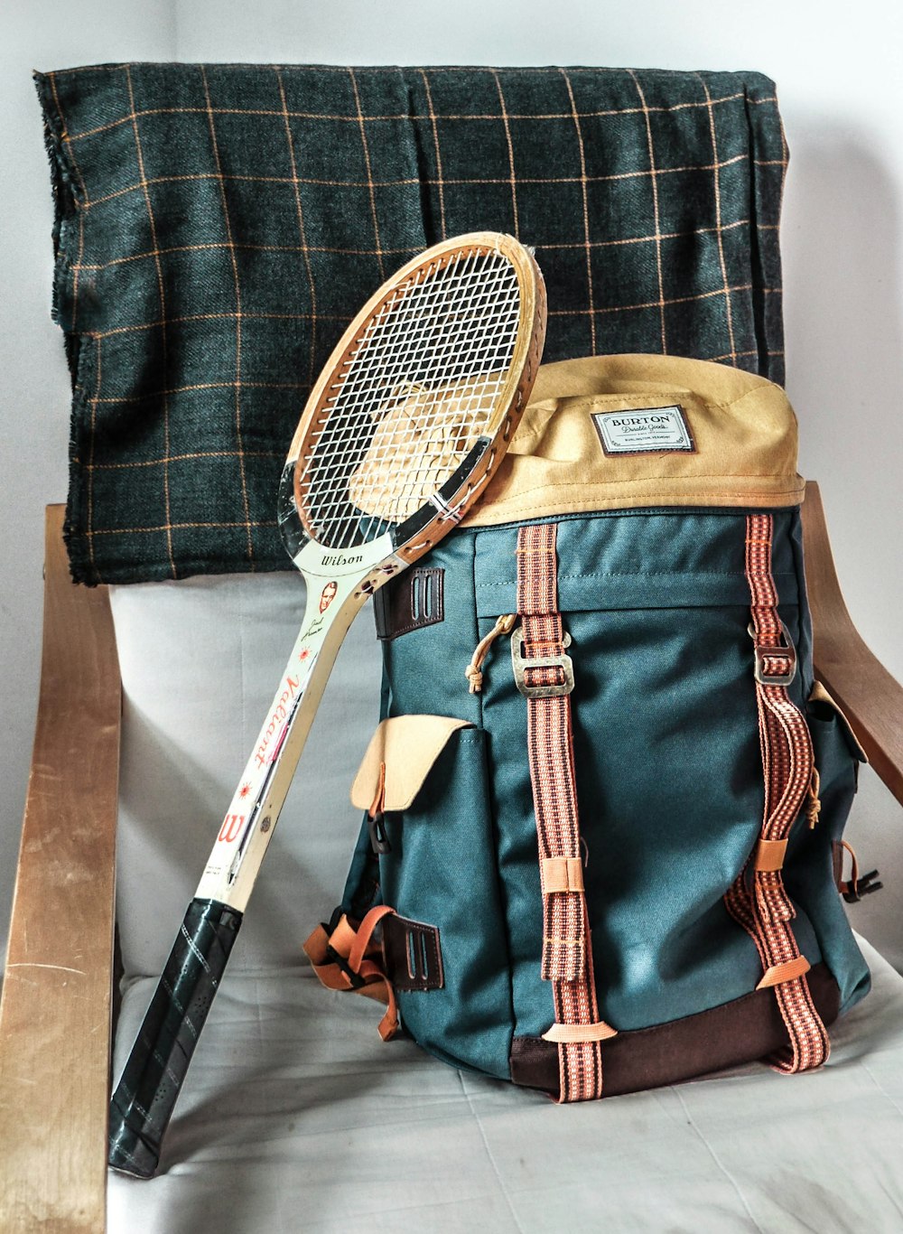 ヴィンテージブラウンのテニスラケットとグリーンのハイキングバックパック