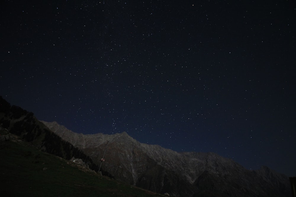 夜の星空の下の茶色の山
