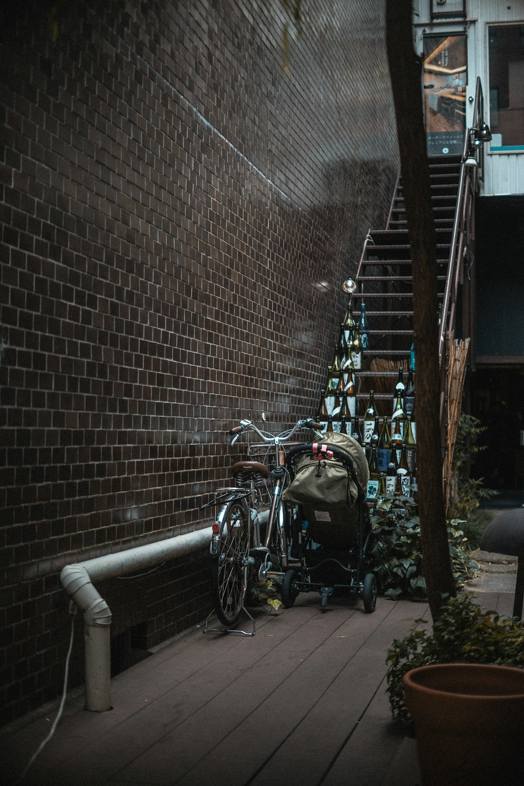 photo of brown stroller beside bicycle leaning on wall