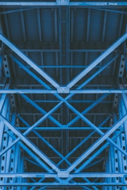low-angle photography of grey metal beams and roof