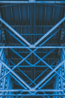 low-angle photography of grey metal beams and roof