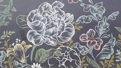 A detailed, ornate illustration of various flowers and leaves with intricate line work. The composition includes large flowers resembling peonies and lilies, with additional smaller flowers and various leaves surrounding them. The background is a dark color, which contrasts with the lighter outlines and shading of the flowers.