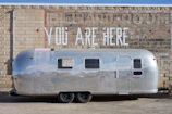 Enclosed trailer with shiny galvanized finish parked outside.