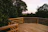 A freshly completed wooden deck overlooking a lush, green backyard in soft evening light.