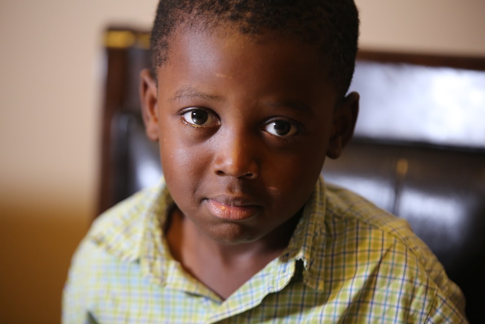 selective-focus photography of boy wearing green plaid shirt