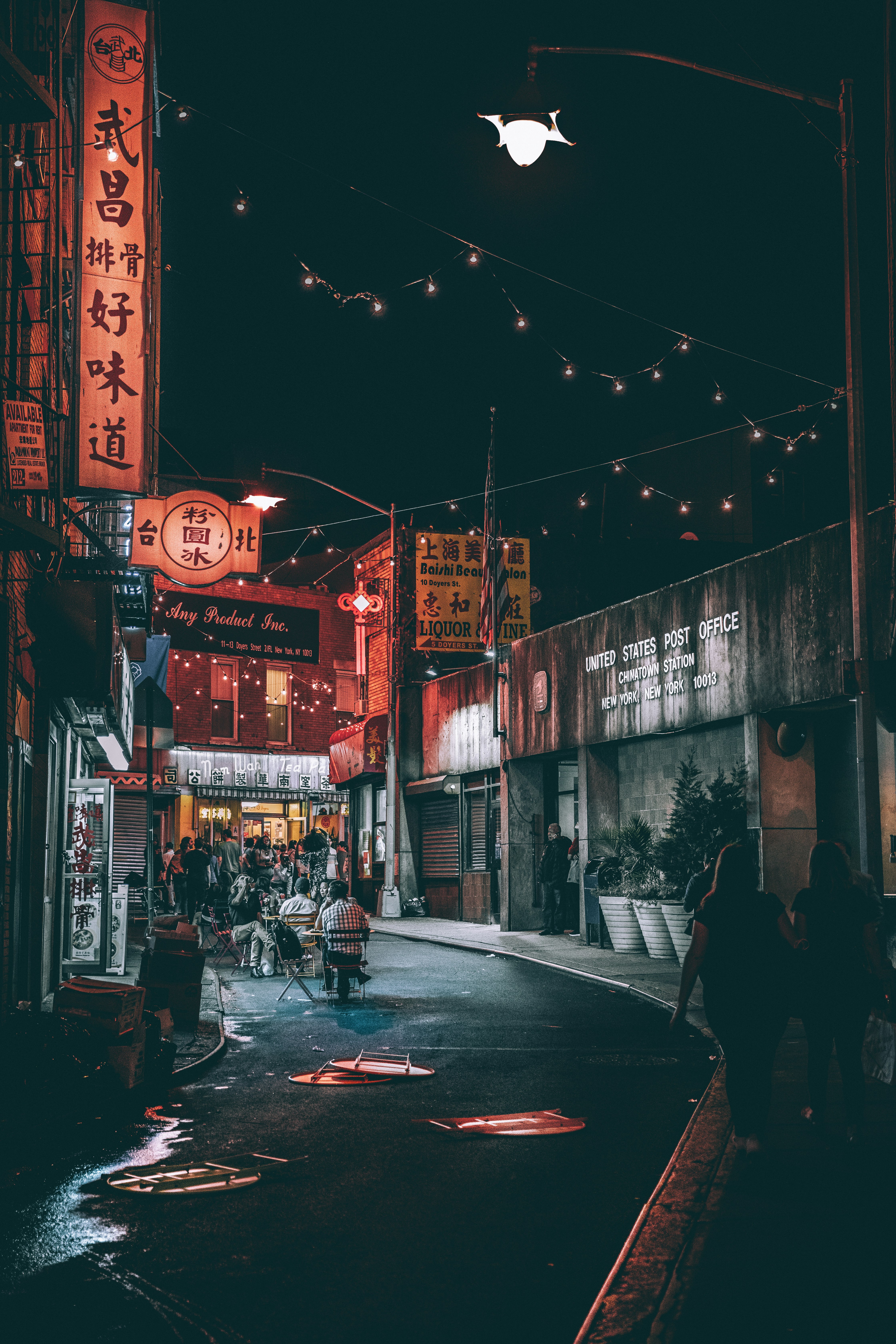 people between gray buildings during nighttime