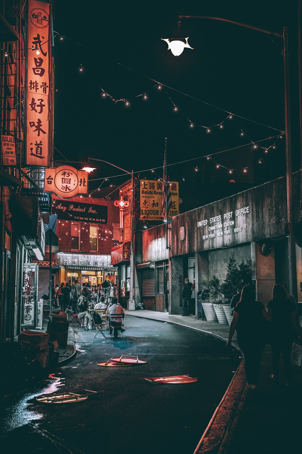 people between gray buildings during nighttime