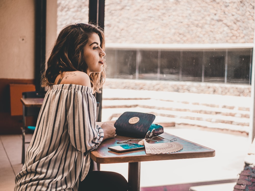 woman sitting infront of brown table