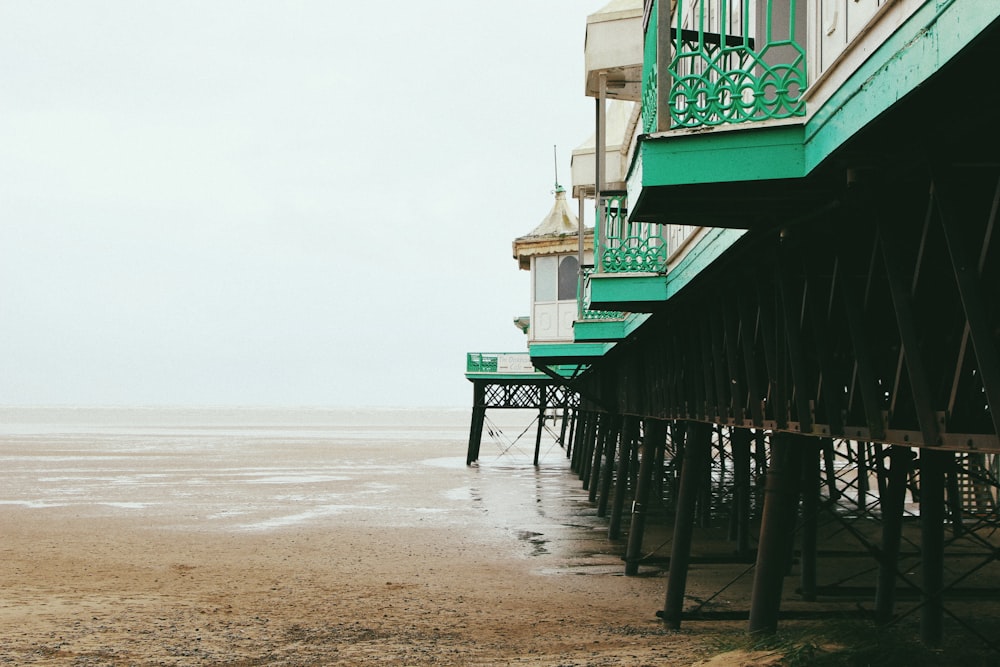 Photographie d’architecture d’un bâtiment vert et blanc au bord de la mer