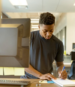 man writing on white paper