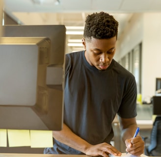 man writing on white paper