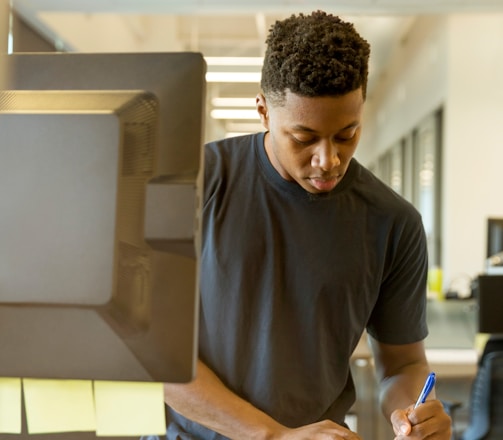 man writing on white paper