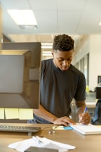 man writing on white paper