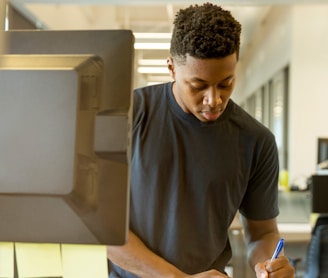 man writing on white paper