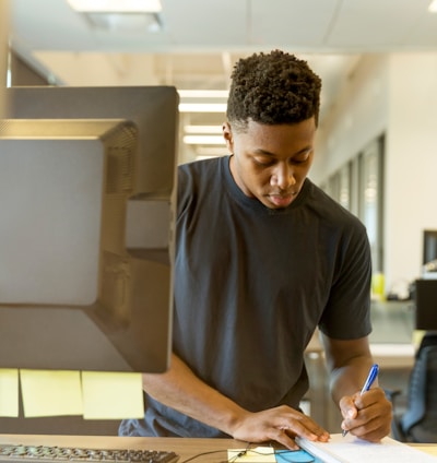 man writing on white paper