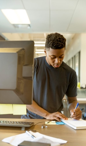 man writing on white paper