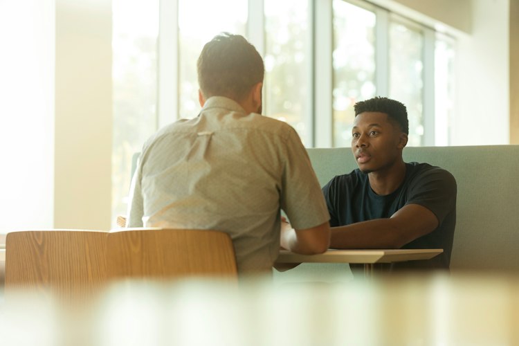 Close-up of hands resting calmly on a table during a quiet conversation