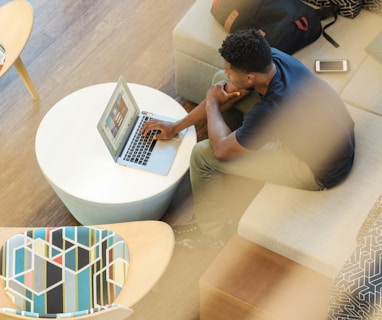 man sitting on couch using MacBook