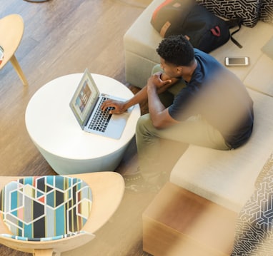 man sitting on couch using MacBook