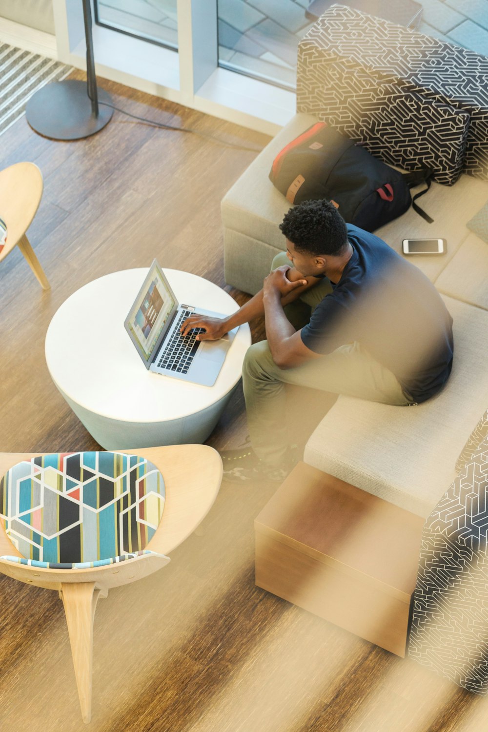 man sitting on couch using MacBook