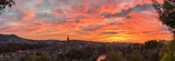 A panoramic view of the Amazon river at sunset, with vibrant orange and pink skies.