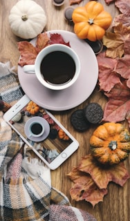 a cup of coffee and a cell phone on a table