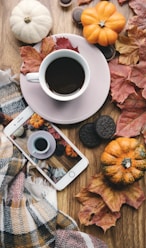 a cup of coffee and a cell phone on a table