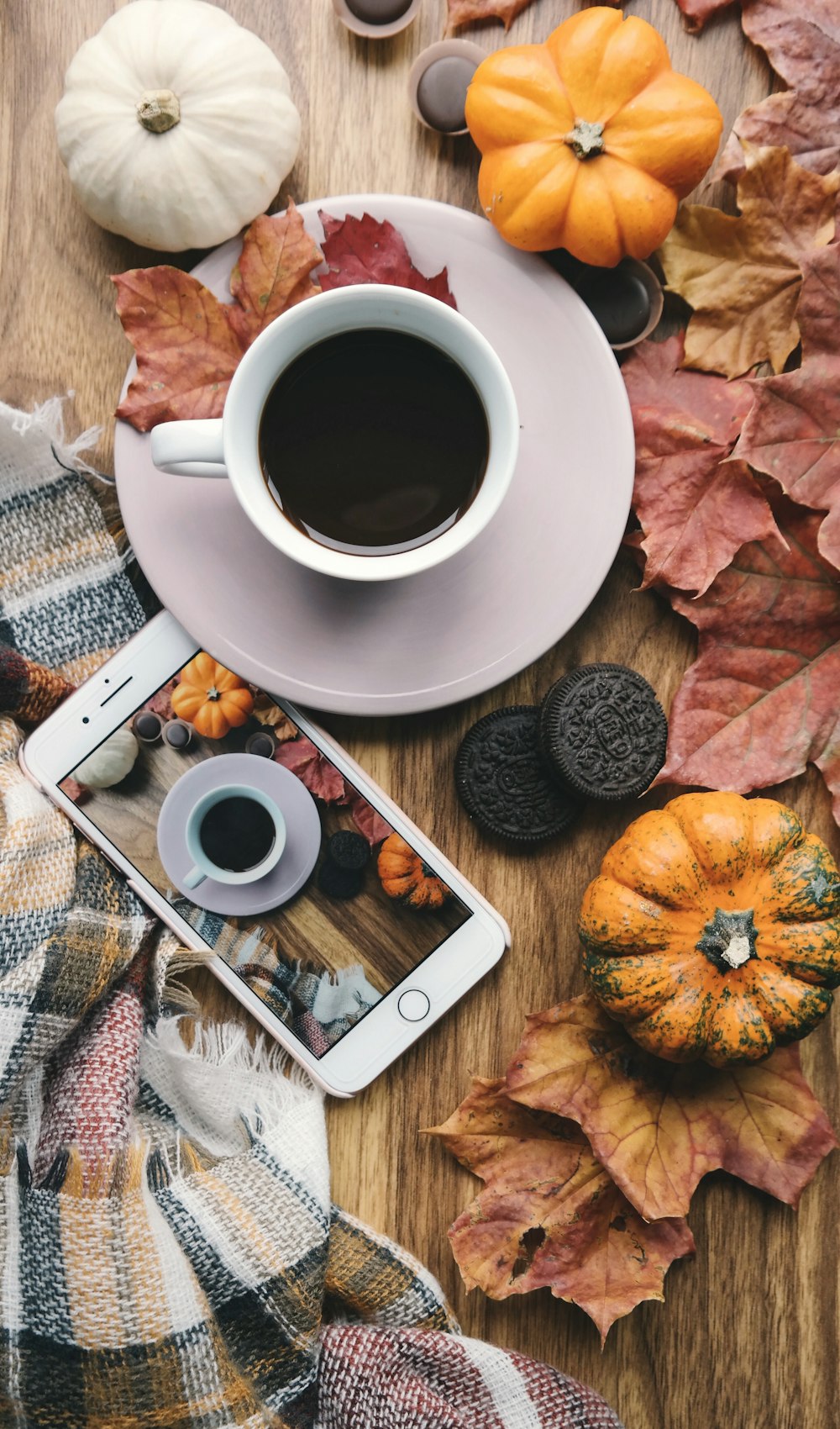 a cup of coffee and a cell phone on a table