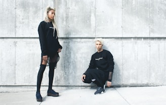 man kneeling and woman standing near wall