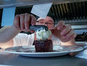 Pastry chef carefully icing a delicate vanilla cake in the kitchen