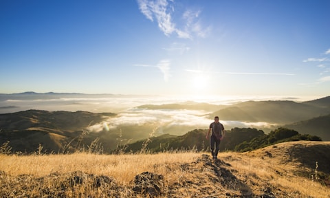 man walking on mountain during daytime