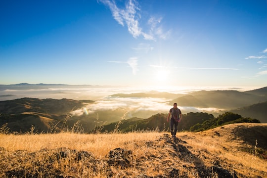 man walking on mountain during daytime in Mount Umunhum United States