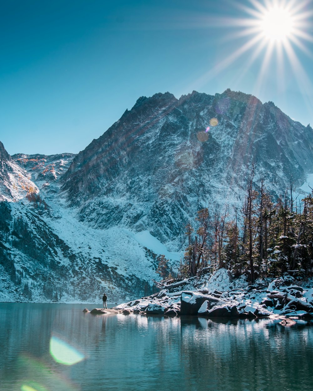 man standing beside of the lake