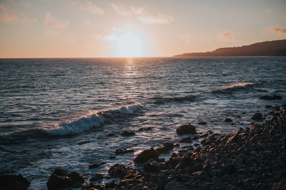 rocks on seashore during sunset