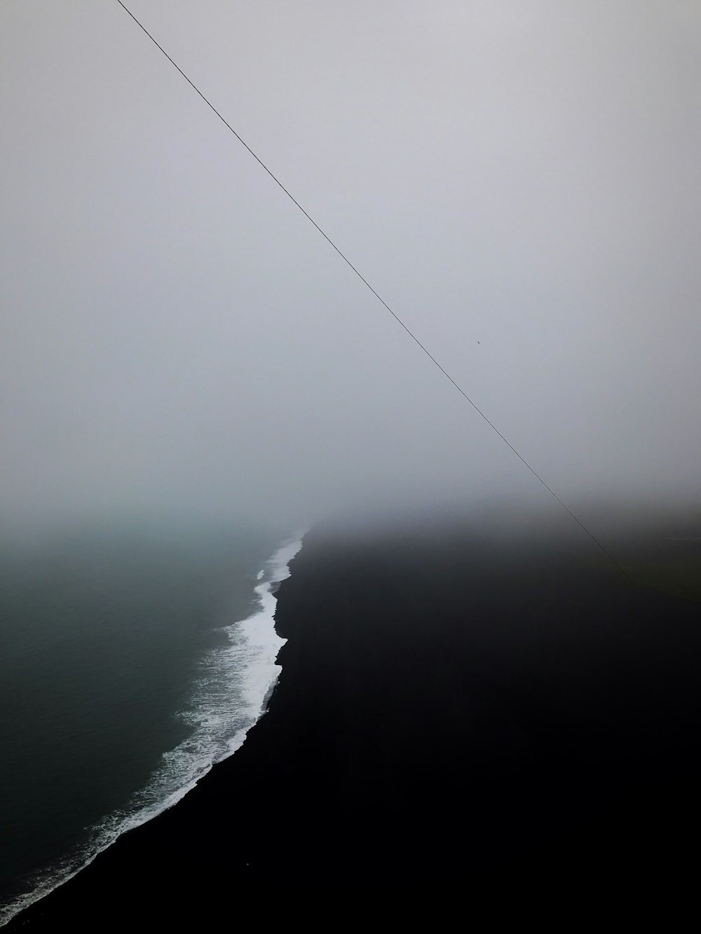 aerial view photography of body of water surrounded by fogs