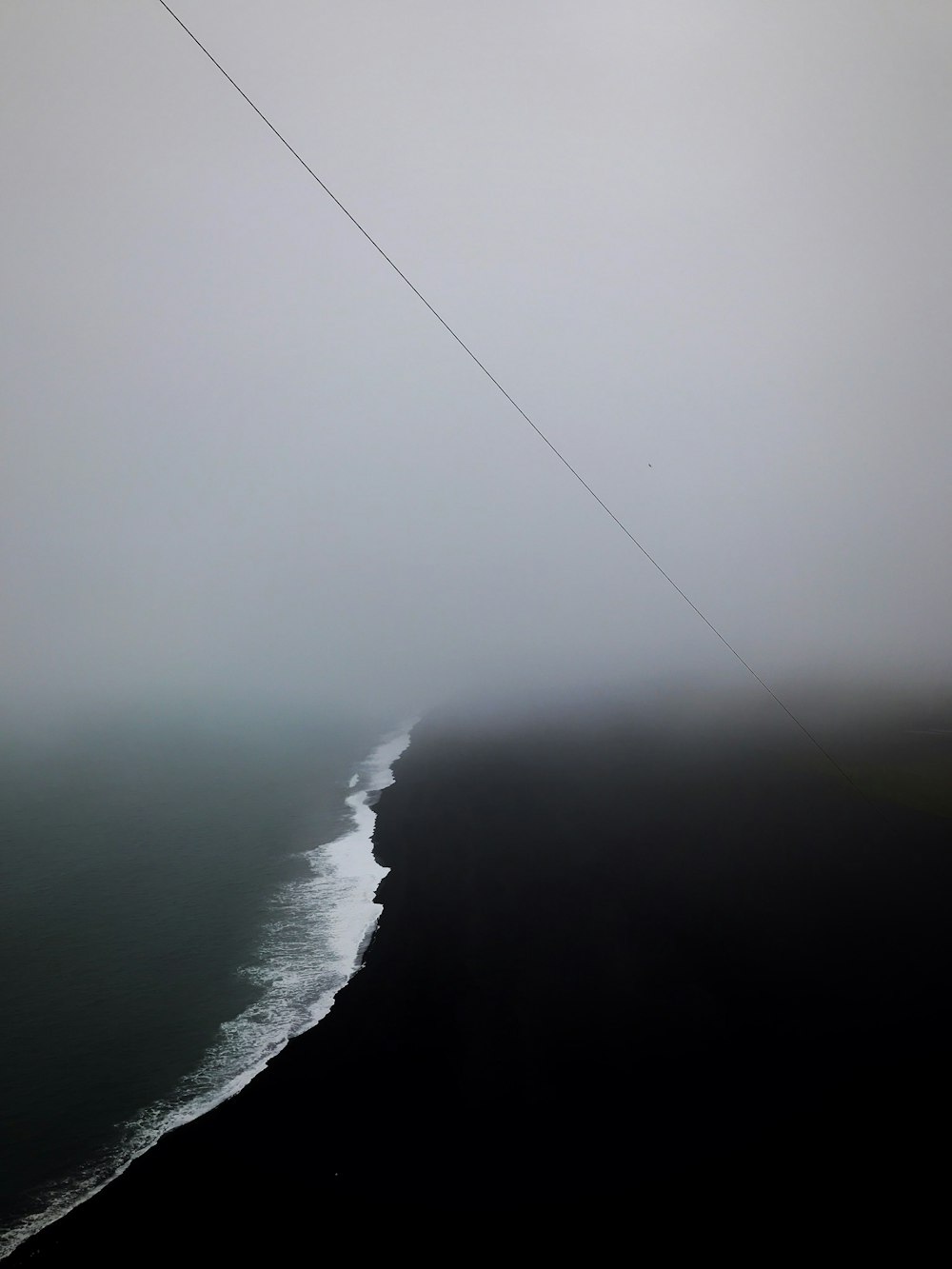 Photographie de vue aérienne d’un plan d’eau entouré de brouillards